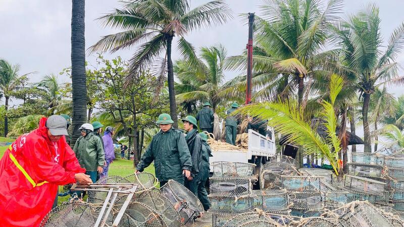 Lực lượng Đồn Biên phòng Nhật Lệ giúp ngư dân thu gom vật chất tàu cá bị chìm.