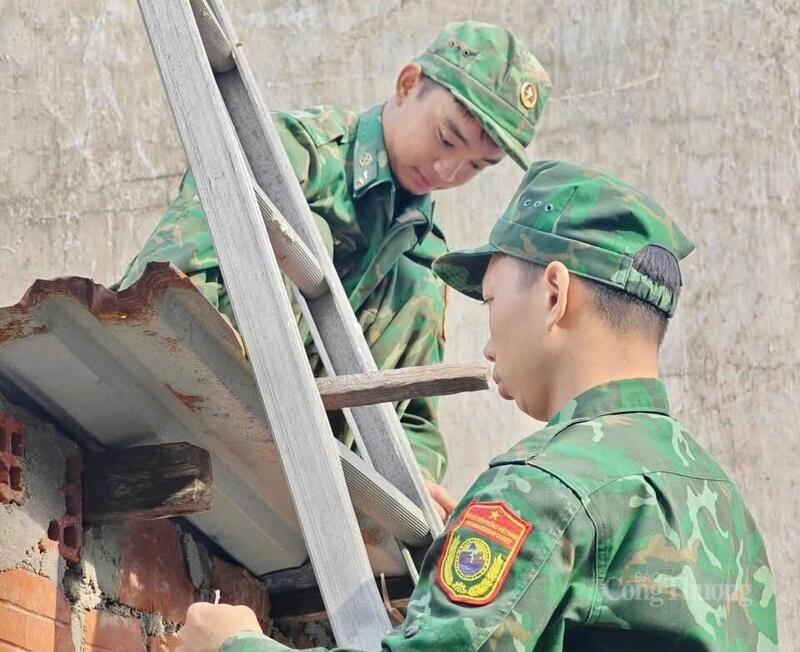 Các chiến sĩ đang gia cố lại mái nhà giúp người dân.