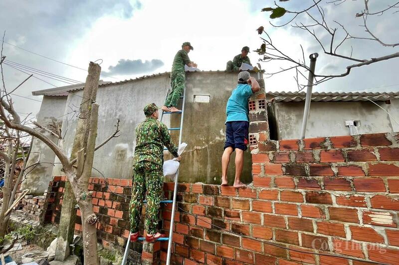 Cán bộ, chiến sĩ Đồn Biên phòng Nhơn Châu giúp người dân gia cố mái nhà.