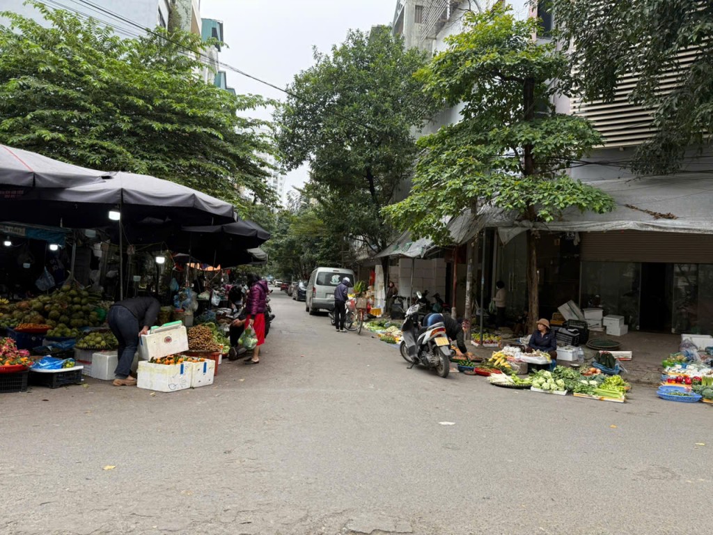 Chợ dân sinh họp tràn ra lòng đường – Xe máy, người mua bán đan xen trong không gian chật hẹp.