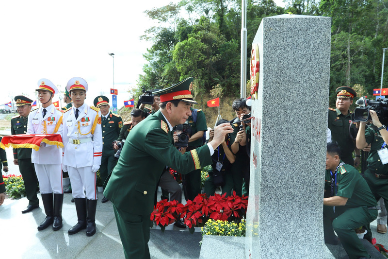 Đại tướng Phan Văn Giang tô son cột mốc chủ quyền. Ảnh: Ngọc Lâm